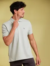 Chomba color verde claro con logo bordado de un pájaro en el pecho.