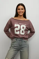 Buzo de cuello bote y manga larga, color marrón con estampa frontal en blanco que incluye el texto 'LOS ANGELES' y el número '28'.