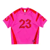 Camiseta de básquet de malla en color rosa con detalles en rojo. Presenta el número 23 estampado en el frente y en las mangas, con el logo de Jordan bordado en el cuello y un parche con la marca Supreme en la parte inferior.