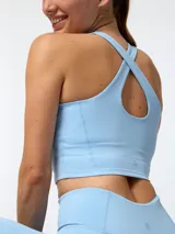 Top deportivo celeste de corte crop, con cuello redondo y diseño ajustado.