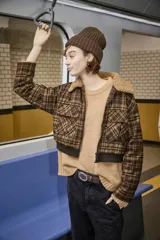 Campera tipo bomber de corte cropped, con estampado de cuadros en tonos marrones. Presenta cuello de piel sintética, cierre frontal con cremallera, bolsillos frontales con solapa y puños y cintura de tejido elástico acanalado.