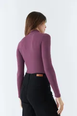 Polera negra de cuello alto y manga larga, de corte ajustado.