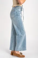 Jean wide leg de tiro medio en color celeste claro, con lavado clásico y cordón ajustable en la cintura.