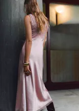 Vestido largo lencero de satén color rosado, con escote en pico, tirantes anchos, panel de encaje en el pecho y detalles de encaje en el bajo.