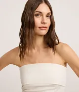 Blusa strapless de sastrería color blanco marfil con sutiles rayas verticales, escote recto doblado y diseño entallado.