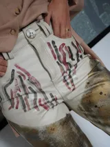 Pantalón de cuero color negro con estampado artístico en fucsia y blanco.