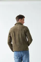 Campera de gamuza color verde oliva, con cuello medio, bolsillos tipo cartera y cierre frontal con botones.