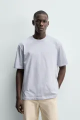 Camiseta regular fit de color beige, confeccionada en tejido de algodón compacto, con cuello redondo y manga corta.
