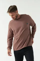 Remera de hombre negra de manga larga con puños, escote redondo y bolsillo en el pecho con etiqueta de marca.