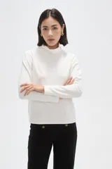Polera de manga larga con cuello alto, confeccionada en tejido de punto suave.