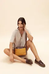 Bandolera semirrígida Sagali de cuero vacuno color bordó, con textura de cocodrilo en el bolsillo frontal y cuerpo liso. Cuenta con cierre superior y correa regulable.