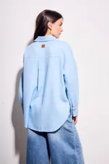 Camisa oversize de lino y viscosa color celeste, con cuello clásico, cierre frontal con botones y mangas largas.