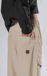 Pantalon cargo color vison de silueta oversize y pierna recta ancha. Cuenta con cintura elastizada, cinturón integrado con hebilla de seguridad, múltiples bolsillos laterales con solapa y detalles reflectivos.