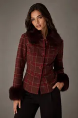 Chaqueta entallada de diseño clásico con estampado de cuadros escoceses en tonos bordó. Presenta cuello y puños con detalle de pelo sintético al tono, cierre frontal con botones y corte ajustado.
