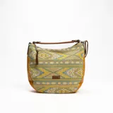 Cartera tipo hobo de tela estampada con motivos geométricos en tonos amarillo, celeste y blanco. Tiene detalles de cuero marrón en la base, laterales y asa.