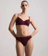Bombacha tipo bikini confeccionada en encaje con textura floral y transparencias delicadas. Presenta un diseño elegante con acabado suave en la cintura y piernas, y forro interior de algodón.