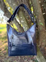 Bolso shopper de cuero vacuno color azul marino, con diseño hobo, panel frontal en relieve efecto croco brillante, bolsillos externos con cierre y correa ancha ajustable.