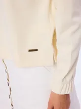Buzo de piqué color beige, de manga larga, cuello redondo y diseño liso.