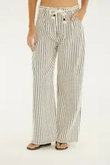 Pantalón de denim blanco con rayas verticales negras, de tiro medio y corte ancho. Cuenta con cintura ajustable con cordón y bolsillos laterales.