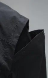 Chaqueta técnica liviana de microfibra con acabado mate, diseño con mangas desmontables que permiten convertirla en chaleco. Cuenta con cuello tipo camisa, cierre frontal oculto, cuatro bolsillos frontales de gran tamaño y puños elásticos. Incluye logo bordado en relieve en el pecho.
