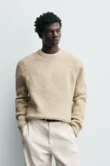 Sweater de punto color beige, de corte relajado, con cuello redondo y diseño texturizado en estructura waffle.