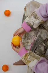 Canguro deportivo con capucha, color rosa y lila, con estampado de hojas y flores.