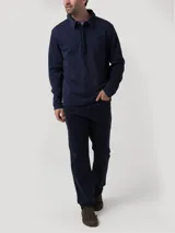 Buzo de algodón orgánico azul marino con cuello camisero, manga larga y medio cierre abotonado con solapa tapada.