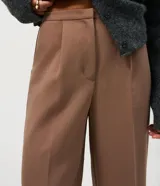Pantalón de sastrería color negro, de corte recto, con pretina fina, pinzas frontales y bolsillos.