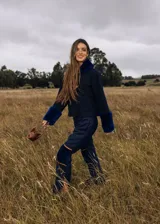 Pantalón de lana azul marino, de corte recto, con rodilleras de corderito en el mismo tono y detalles de ribetes tostados.