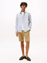 Camisa celeste de algodón regenerativo con textura dobby, cuello camisero clásico, cierre con botones y puños abotonados. Tiene corte regular, manga larga y logo de Tommy Hilfiger bordado en el pecho.