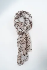 Pañuelo rectangular de tela ligera y semitransparente con estampado abstracto en tonos marrones y beige.