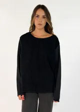 Blusa de manga larga con cuello redondo y detalle de alforzas verticales en el frente. Presenta un diseño holgado y minimalista.