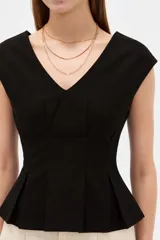 Blusa de lino color blanco, con cuello en V, pinzas de entalle y diseño al cuerpo con faldón acampanado.