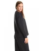 Buzo deportivo de cuello redondo, con hombros caídos y mangas largas con puños. Presenta costuras decorativas tipo pespunte en la parte frontal y en las mangas, con un diseño de ruedo recto y tajos laterales.