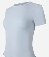 Blusa básica de manga corta, cuello redondo y textura sutil, confeccionada en viscosa con elastano. El bajo de la prenda es ondulado.
