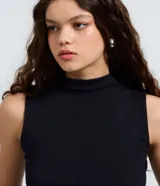 Musculosa básica de cuello alto, sin mangas, confeccionada en una mezcla de algodón, modal y elastano. Presenta un diseño ajustado y minimalista, ideal para uso diario.