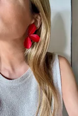 Caravanas con diseño de flor de tres pétalos esmaltados en color rojo intenso.