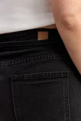 Bermuda larga de jean negro, de corte recto y tiro alto, con largo por encima de la rodilla. Cuenta con un lazo ajustable en la cintura y detalles desflecados en el ruedo.