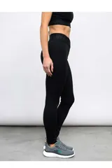 Calza deportiva Umbro para mujer de color negro, de tiro alto con diseño cruzado en la cintura y elástico con la marca impresa.