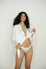 Bombacha less blanca de satén con volados en los bordes.