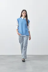 Chaleco tejido de punto con silueta relajada y diseño sin mangas. Presenta lazos laterales ajustables y cuello redondo.