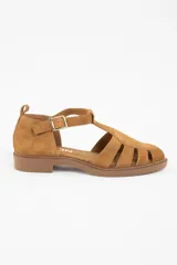 Sandalia tipo cangrejera de gamuza color camel, con diseño de tiras entrelazadas, puntera cerrada y cierre con hebilla metálica lateral.