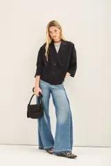 Saco corto de lino con corte oversize y mangas amplias. Presenta un diseño de doble abotonadura frontal y forro interior de lino.