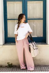 Pantalón de tiro alto y corte suelto en color rosado, con cintura elástica ajustable mediante cordón y bolsillos laterales.