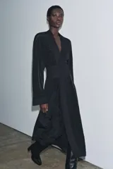 Kimono largo de manga larga con diseño abierto, confeccionado en tejido satinado negro. Presenta detalles de bordados florales a tono en el frente y en los puños, e incluye un cinturón tipo fajín ajustable con lazadas en la cintura.