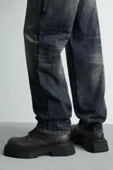 Bota tipo derby con cordones, confeccionada con acabado efecto desgastado. Presenta horma redonda y suela gruesa con diseño track.