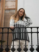 Sweater tejido a rayas horizontales color beige, marrón y negro, de cuello alto y corte holgado.