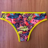 Bombacha vedetina estampada con hojas de palmera en tonos coral, negro, verde y celeste, con terminaciones en amarillo flúor.
