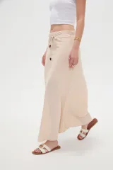 Falda larga color beige de modal, con cintura ajustable mediante cordón con detalles de cuentas en las puntas.