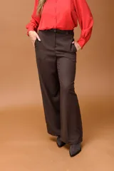 Pantalón sastrero de corte ancho y tiro alto, con diseño de líneas limpias, bolsillos laterales y cierre frontal con botón. Presenta una caída fluida y estructura amplia.